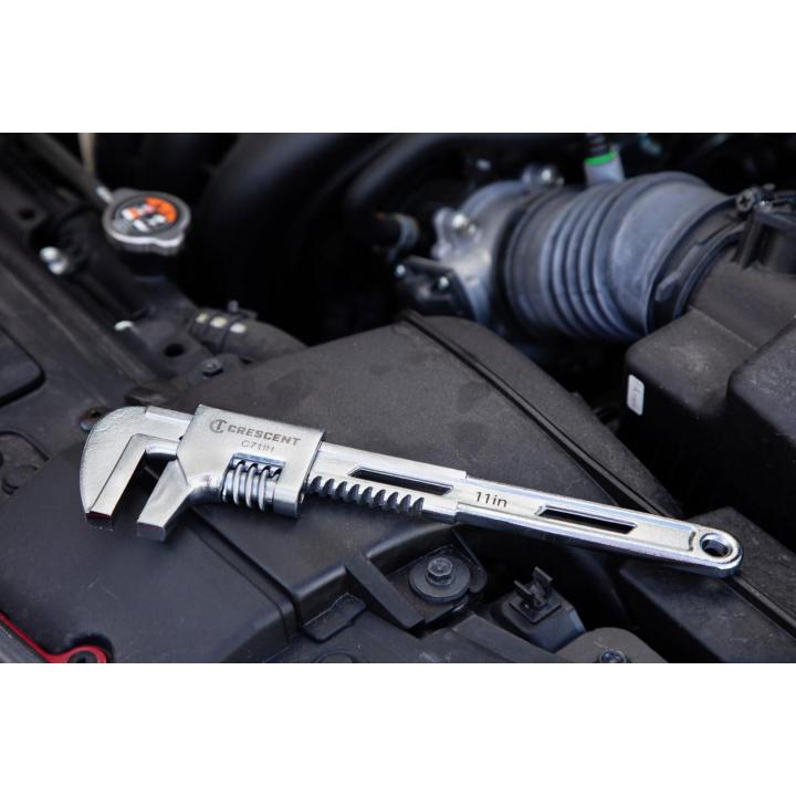 Image of the Crescent 11" Automotive Wrench laying on a car engine