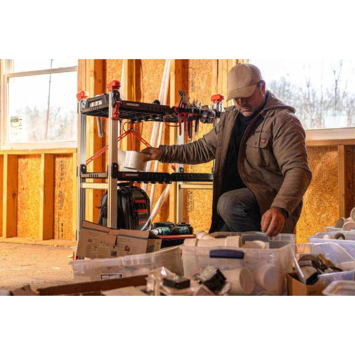 Male plumber adding tools and parts to a Crescent SITERUNNER folding cart inside new residential construction site