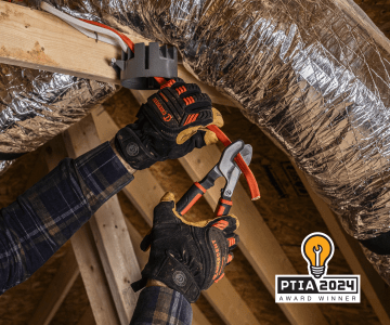 Man using Crescent 9-1/2" electrical cable cutter to cut orange electrical cable in a new home construction